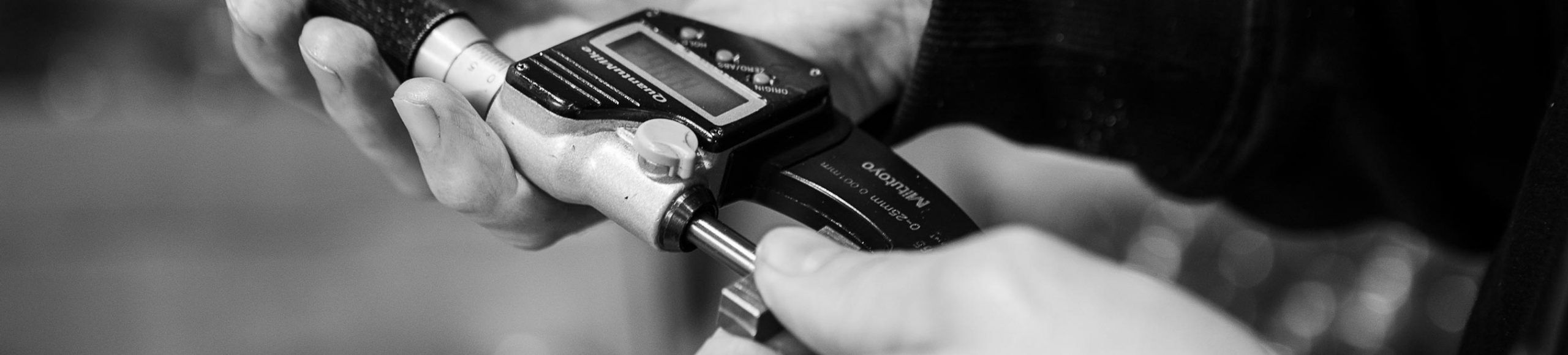 Checking a machined part with a micrometer at SMV